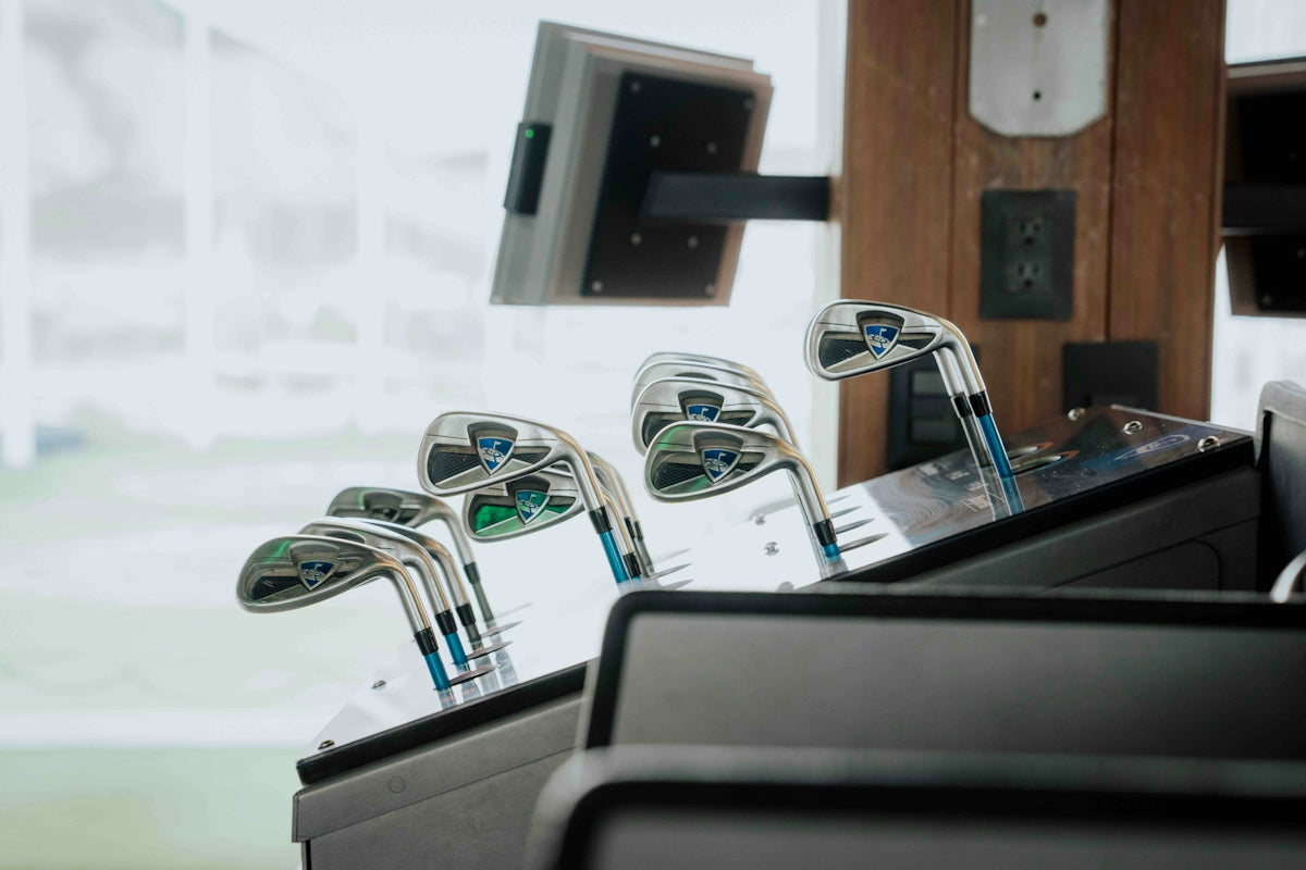 Golf clubs rest in a display