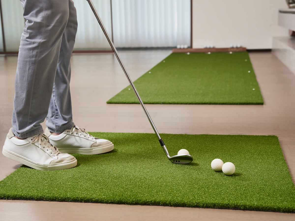 Person practicing golf swing indoors on a mat