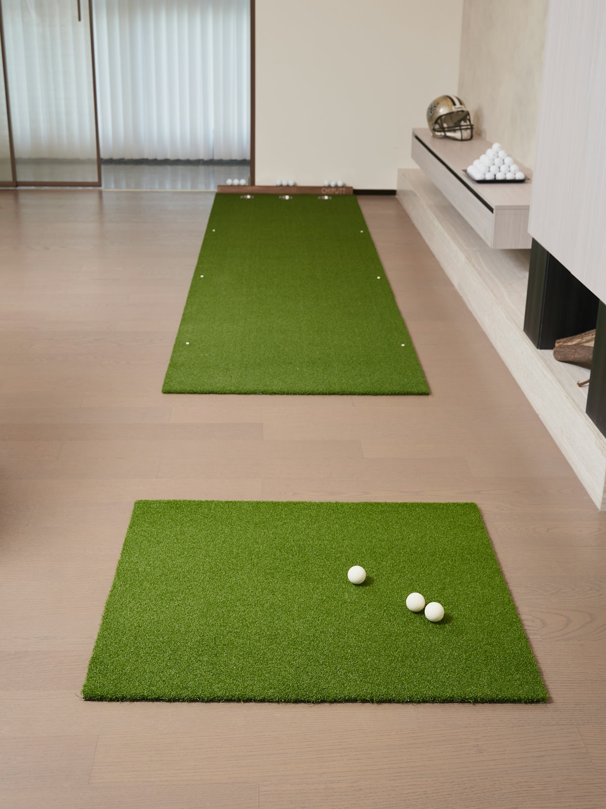 Two golf mats with balls on wooden floor