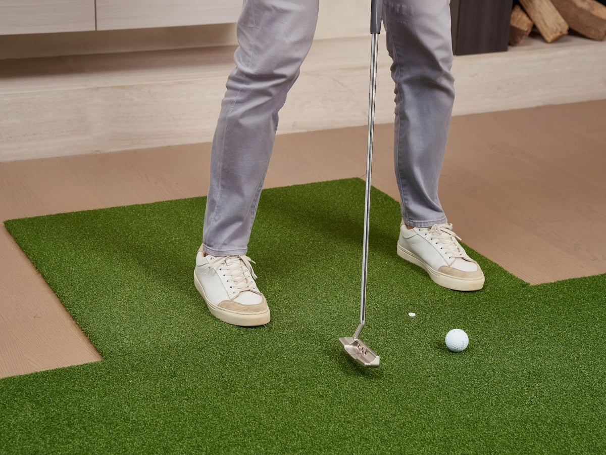 Person putting a golf ball on indoor putting green