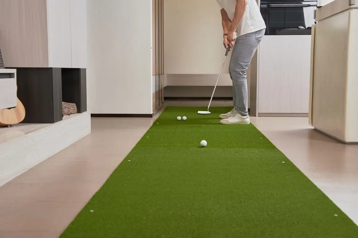Person practicing indoor putting on a green mat.