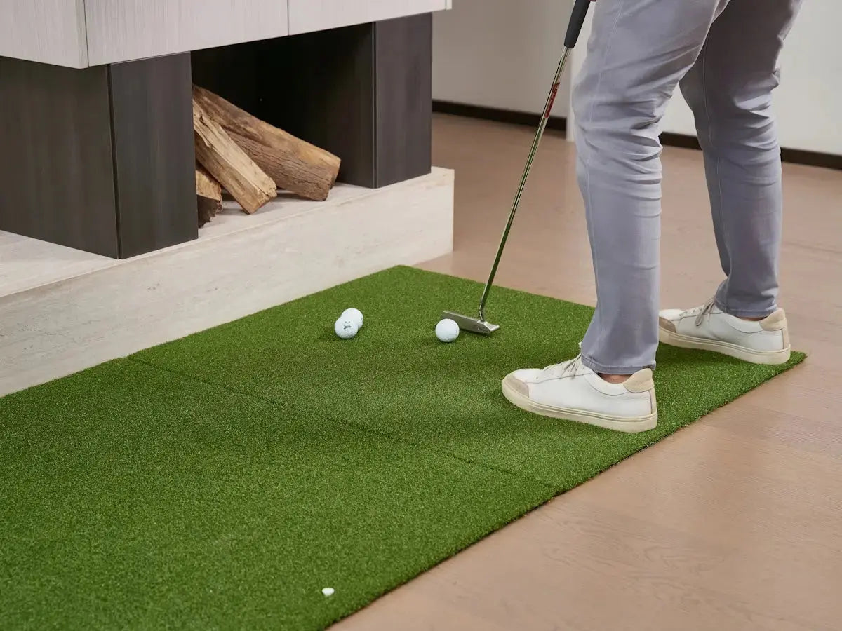 Man practicing golf putting indoors on indoor green mat