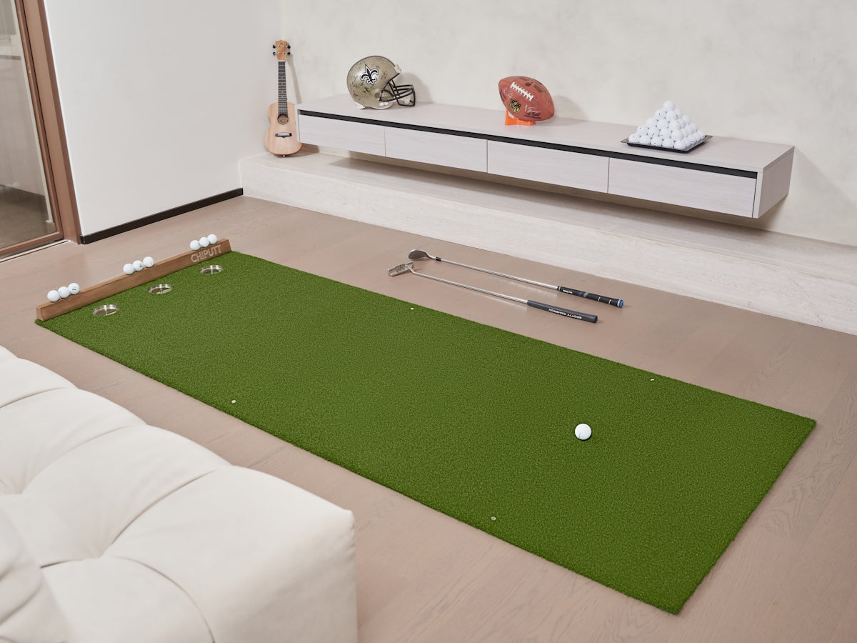 Golf putting green with putter and ball indoors.