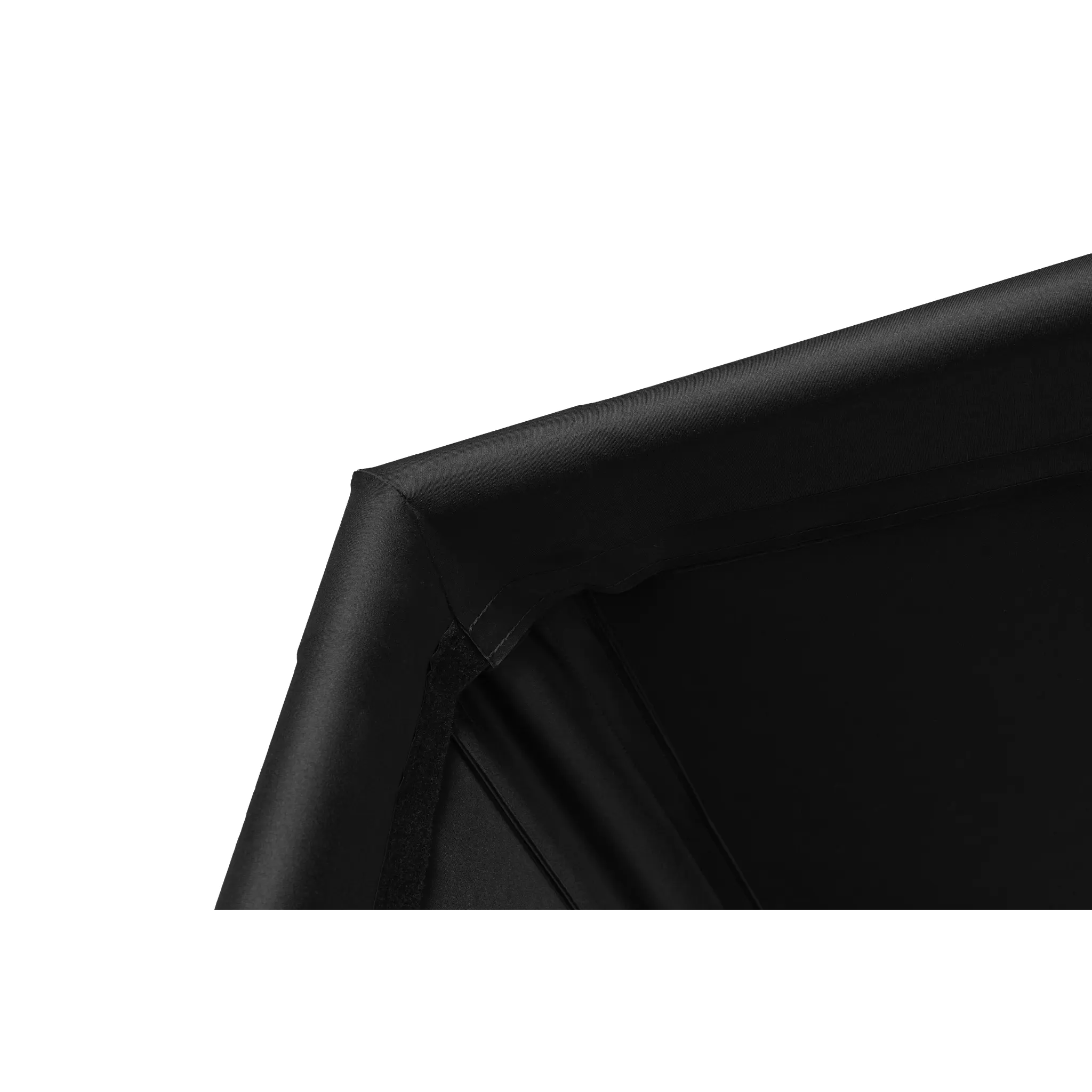 Close-up of a black fabric corner of a golf simulator enclosure, showcasing the sturdy stitching and smooth finish. The material appears durable and designed for professional indoor golfing setups.