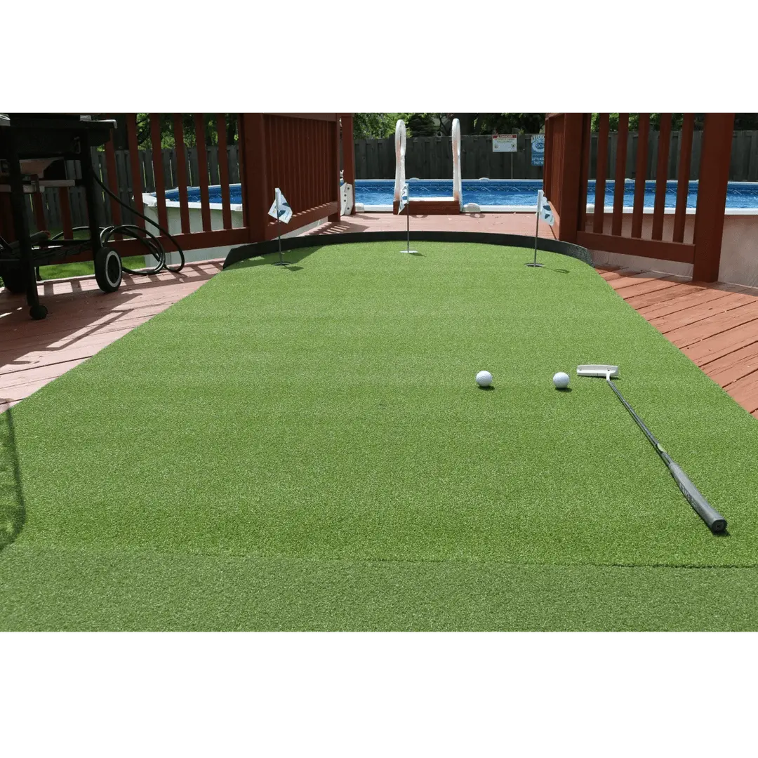 Big Moss Commander Patio Series 615 putting green shown set up near a pool with clubs and golf balls on the surface