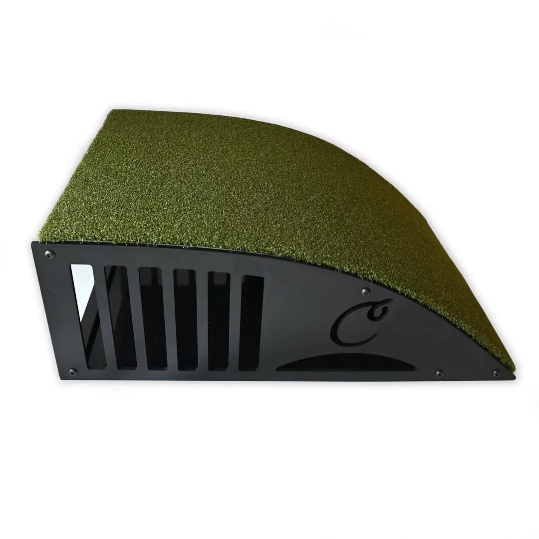 Black ramp with green turf for floor mounted projector enclosure, angled view