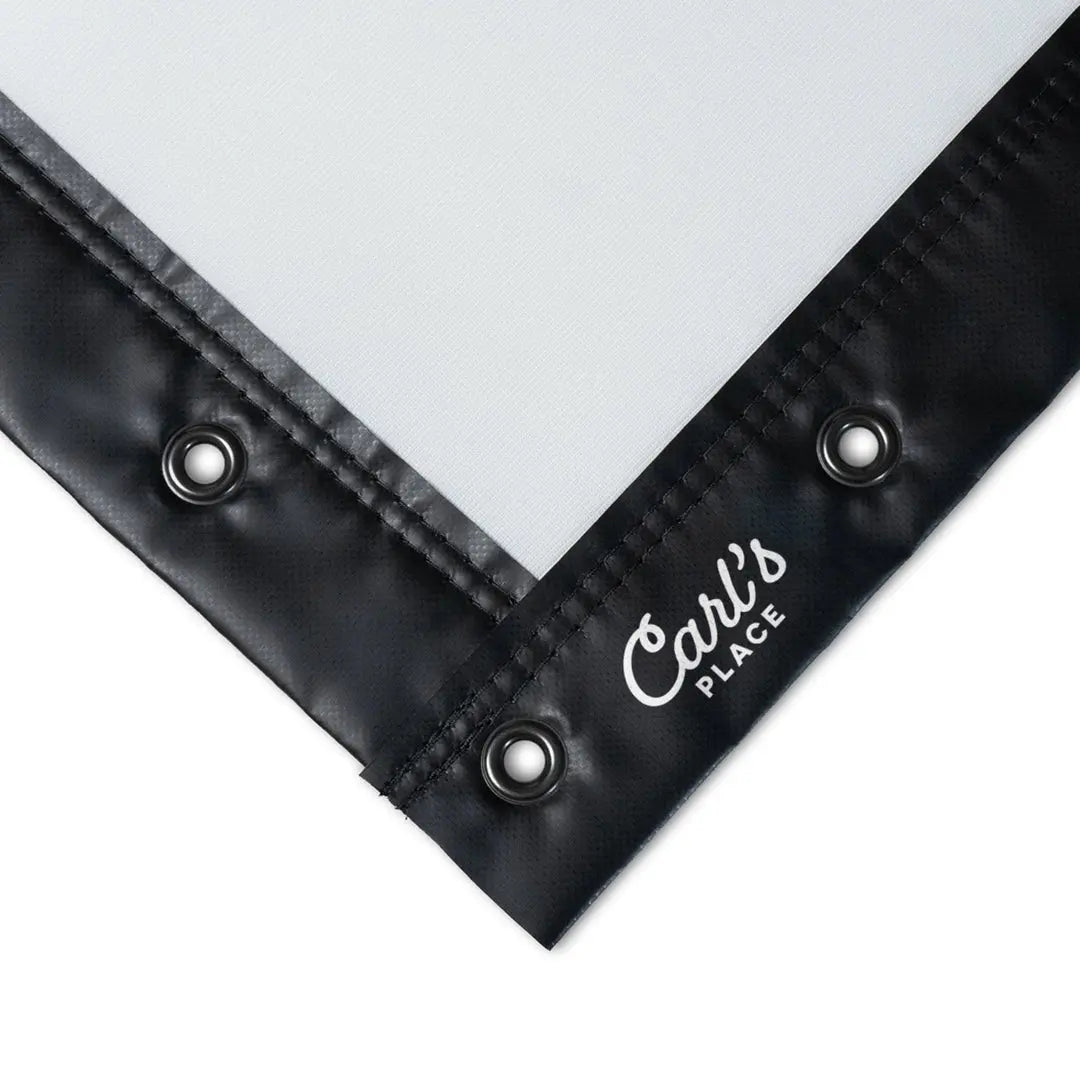 Close-up of Golf Impact Screen corner showing black edges, metal grommets, and logo tag.