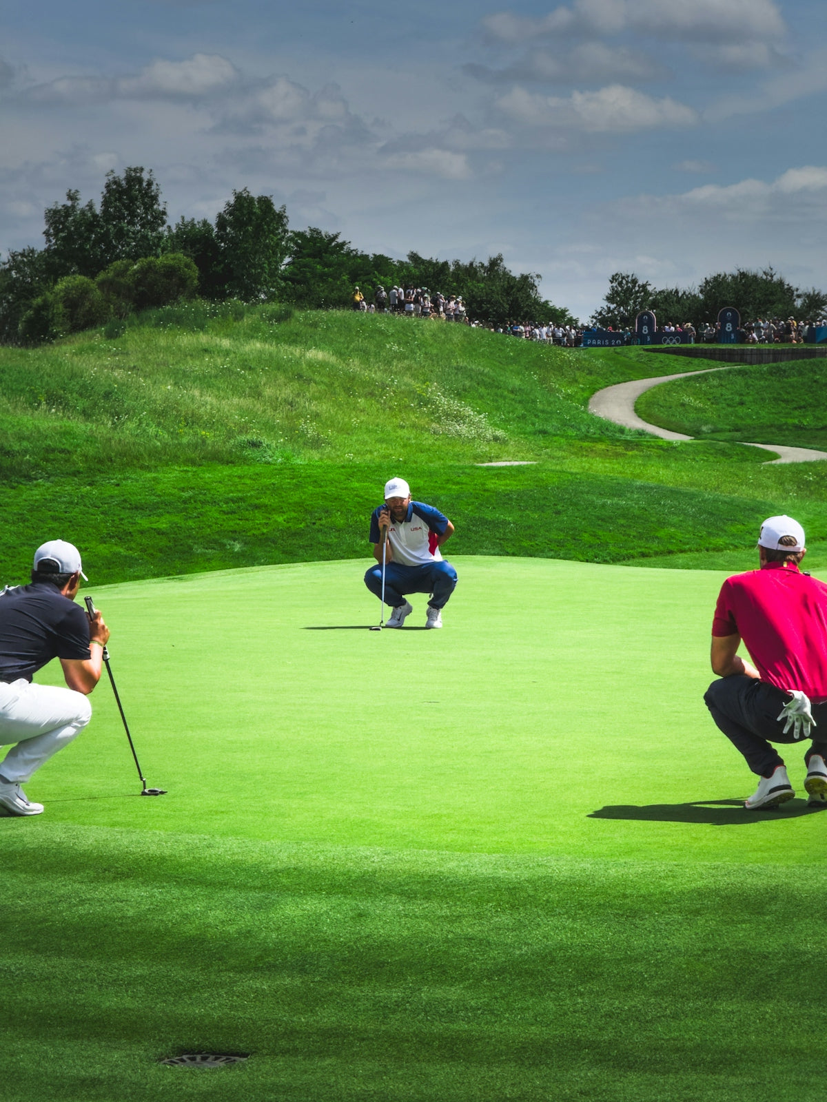 A group of people playing golf on a green course